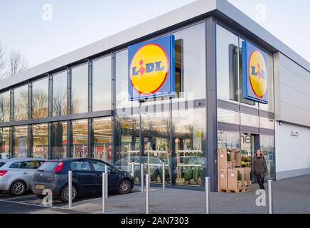 BUCKINGHAM, Großbritannien - 04. Dezember 2019. Lidl Supermarkt store Exterieur, mit Frau Shopper vor dem Eingang. Stockfoto