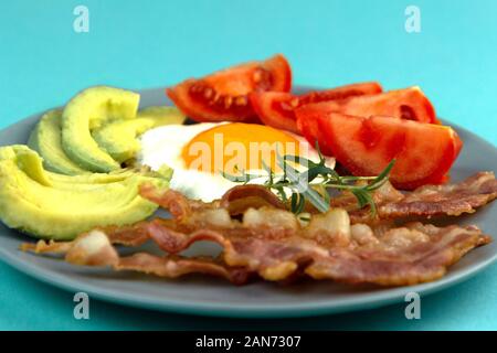 Gesunde keto Frühstück mit Spiegelei und Speck, Avocado und Tomaten. Ketogenic Diät Ernährung. Stockfoto