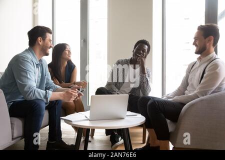 Lächelnd multiethnischen Kollegen Lachen im Büro treffen kooperierenden Stockfoto