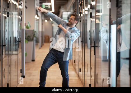 Leidenschaftlich gerne männliche Mitarbeiter Tanz im Büro feiern Stockfoto