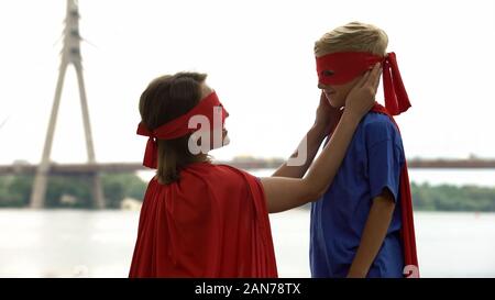 Fürsorgliche Mutter in Superhelden Kostüm mit Liebe auf den Sohn, stolz auf ihr Kind Stockfoto