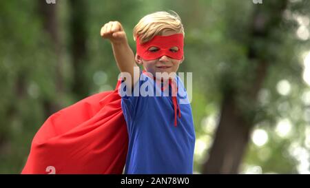 Superhelden Junge spielt im Park, der vorgibt zu fliegen, brave Kind und Sieger Konzept Stockfoto