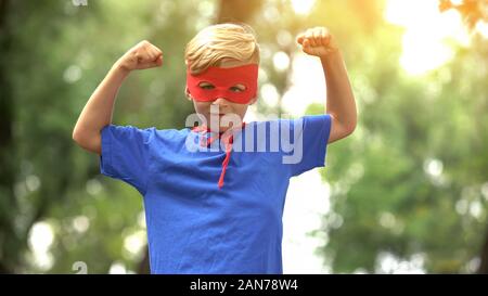 Superhelden boy zeigt Muskeln, Spiel, wie Psychotherapie für das Kind vertrauen Stockfoto