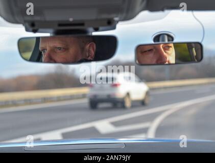 14. Januar 2020, Brandenburg, Frankfurt (Oder): Im Rückspiegel Ihres Fahrzeugs, die Gesichter von Sven Umland (l), Leiter der Polizei der föderalen Polizei und Damian Kuzynin, aus der polnischen Grenzbeamten, können auf der Autobahn 12 gesehen werden. Deutsche und polnische Grenzschützer patrouillieren Oder und Neisse zusammen, und seit dem Herbst auch Patrouillen in neue Fahrzeuge wurden. Dennoch, der Kampf gegen die grenzüberschreitende Kriminalität bleibt schwierig, nicht zuletzt aufgrund der Verkehrsdichte. Foto: Patrick Pleul/dpa-Zentralbild/ZB Stockfoto