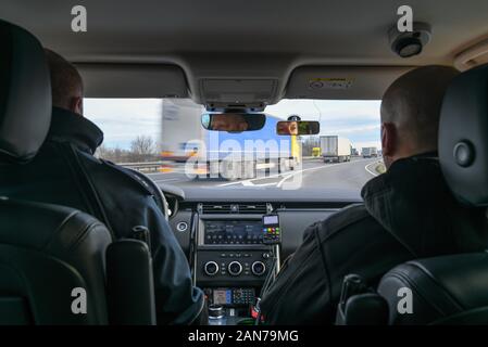 14. Januar 2020, Brandenburg, Frankfurt (Oder): Sven Umland (l), Senior Polizeichef an der Föderalen Polizei und Damian Kuzynin aus der polnischen Grenzbeamten warten in Ihrem Fahrzeug auf der Autobahn 12, während die deutschen und polnischen Grenzbeamten Patrouille Oder und Neisse zusammen, und seit dem Herbst auch Patrouillen in neue Fahrzeuge wurden. Dennoch, der Kampf gegen die grenzüberschreitende Kriminalität bleibt schwierig, nicht zuletzt aufgrund der Verkehrsdichte. Foto: Patrick Pleul/dpa-Zentralbild/ZB Stockfoto