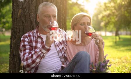 Gerne älteres Paar Wein trinken und genießen romantisches Date im Park, Liebe Stockfoto