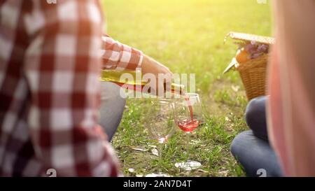 Pensionierter Ehemann gießen rot Wein in die Gläser und das Behandeln der schönen Frau, Datum Stockfoto