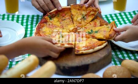 Freunde Hände unter Scheiben köstliche italienische Pizza in Cafe, gute Gesellschaft Stockfoto