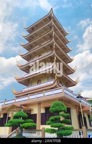 Hohe Pagode in Vinh Trang Tempel, in der Nähe von My Tho, Vietnam. Low Angle Blick aus dem Garten. Stockfoto