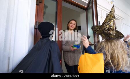 Kinder zu Fuß zum nächsten Haus für Süßigkeiten an Halloween, trick-or-Behandlung Stockfoto