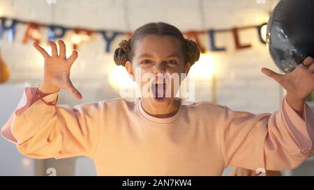 Kleines Mädchen erschrecken an Kamera und feiern Halloween Eve, zu Hause feiern Stockfoto