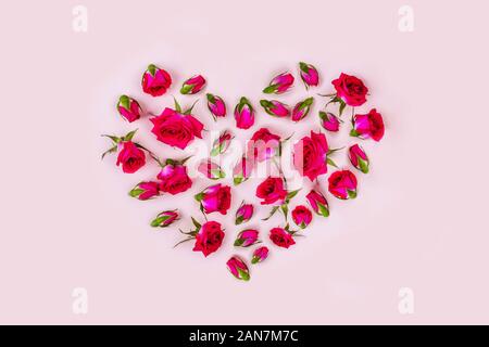 Urlaub Karte, rote Rosen in der Form eines Herzens auf rosa Hintergrund. Valentinstag, Hochzeit, Jubiläum, Geburtstag. Stockfoto