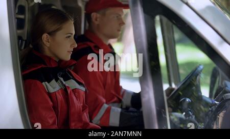Medizinische Arbeiter im Auto sitzen, Fachleute im Dienst erste Hilfe zu leisten. Stockfoto