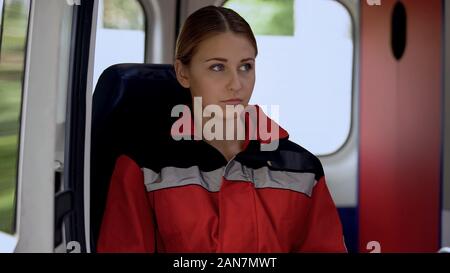 Junge weibliche Sanitäter in Krankenwagen sitzen, bereit, auf Abruf zu Fahren, 911 Stockfoto
