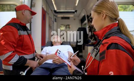 Rettungssanitäter Prüfung Patienten auf Keilrahmen, Kollege Platten zu machen, Rescue Team Stockfoto