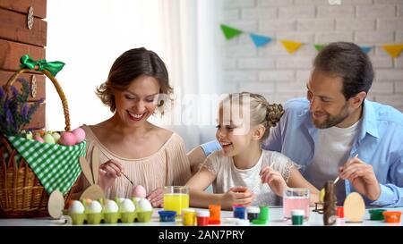 Schöne Familie Verzieren der Ostereier mit bunten Farben, alten Traditionen Stockfoto