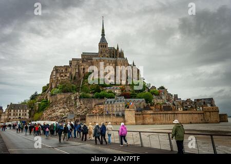 Touristen auf dem Weg zum Mont Saint Michel in der Normandie, Frankreich. Stockfoto