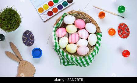 Korb mit bunt gefärbten Eier stehen auf dem Tisch, Ostern Atmosphäre, inspiration Stockfoto