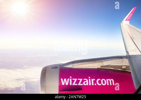 Wien, Österreich - Januar 03, 2020: Wizzair lowcost Wirtschaft Fluggesellschaft Airbus Flugzeug über den Wolken mit hellen Sonne auf Hintergrund fliegen Stockfoto