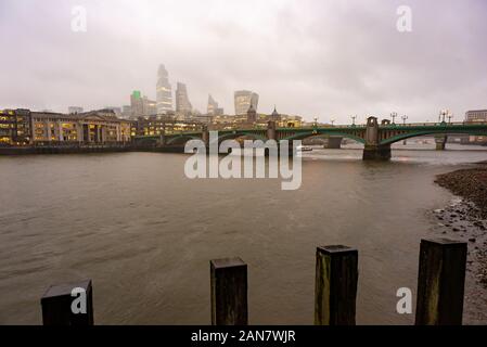 Die Oberseiten der Stadt London Wolkenkratzer verdunkelt durch niedrige Cloud während einer nassen Winter Tag in London, England Stockfoto