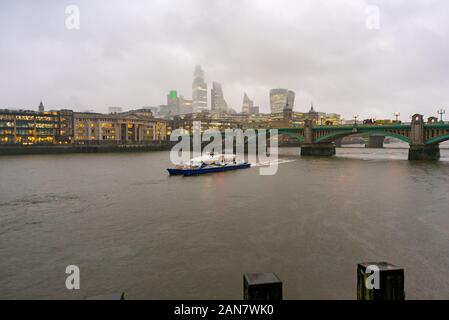 Die Oberseiten der Stadt London Wolkenkratzer verdunkelt durch niedrige Cloud während einer nassen Winter Tag in London, England Stockfoto