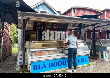 Malmö, Schweden - 29 August 2019: Fisch Verkäufer mit einem Kunden in Fiskehoddorna, traditionellen Fischmarkt auf einer Straße in Malmö, Schweden Stockfoto