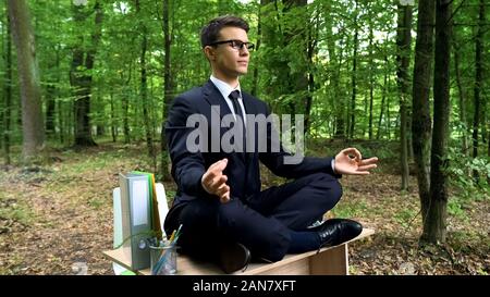 Entspannt Geschäftsmann Meditation in Lotus Position im Freien, Stressabbau am Arbeitsplatz Stockfoto