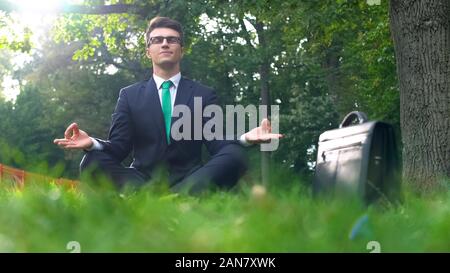 Meditation, Geschäftsmann, sitzen im Lotussitz im Freien, Stressabbau am Arbeitsplatz Stockfoto