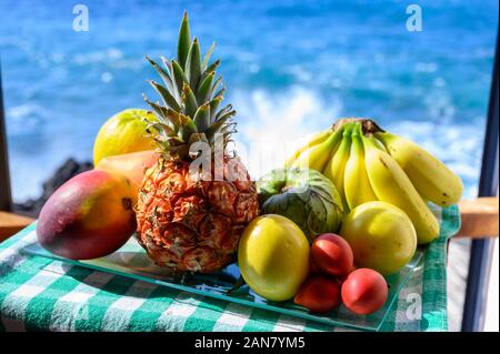 Tropische Früchte Sammlung, Custard Apple oder Grün reif cherymoia, Maracuja, Ananas, Mango, tamarillo, Bananen, exotische Früchte auf blaues Meer backgr Stockfoto