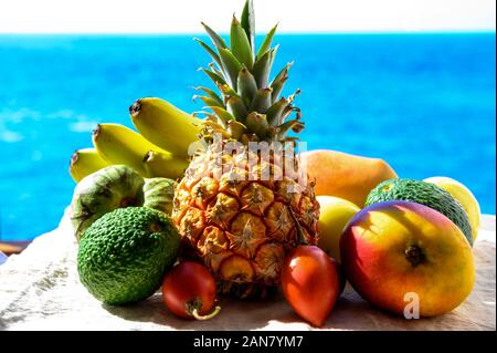 Tropische Früchte Sammlung, Custard Apple oder Grün reif cherymoia, Maracuja, Ananas, Mango, tamarillo, Avocado exotische Früchte auf blaues Meer hinterg Stockfoto
