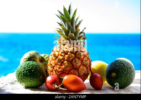 Tropische Früchte Sammlung, Custard Apple oder Grün reif cherymoia, Maracuja, Ananas, Mango, tamarillo, Avocado exotische Früchte auf blaues Meer hinterg Stockfoto
