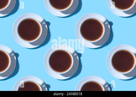 Muster der Tassen schwarzen Kaffee oder Tee auf einem blauen Hintergrund. Stockfoto