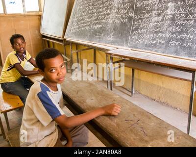 Zwei Jungen in der Klasse Zimmer vor dem Vorstand diskutieren, Togo Bar der Stadt, Äthiopien. Stockfoto