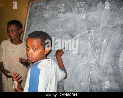 Zwei Jungen in der Klasse Zimmer vor dem Vorstand diskutieren, Togo Bar der Stadt, Äthiopien. Stockfoto