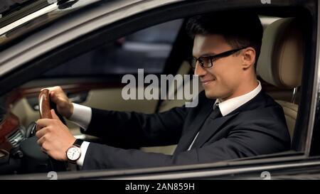 Business Class Fahrer im Auto sitzen, mit neuer Job zufrieden, teures Auto Stockfoto