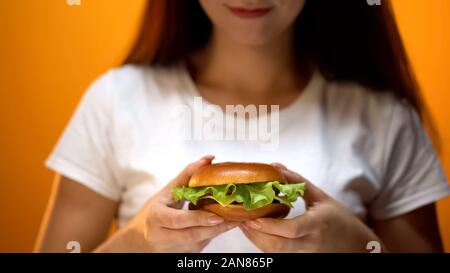 Mädchen, die hausgemachten Burger mit Salat, leckeren Snack, in der Nähe Stockfoto