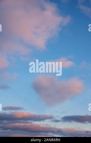 Rosa vanille Wolken auf einem blauen Sonnenuntergang Himmel. Herz geformte Wolke. Valentinstag romantisches Konzept. Stockfoto