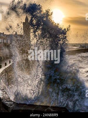 Porthleven Cornwall Uhrenturm, in einem Sturm bei Sonnenuntergang, mit großen Wellen, Wandern in Cornwall, kornische Spaziergänge Stockfoto