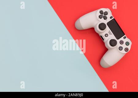 LONDON - Dezember 10, 2019: Video Game Gaming Controller auf hellen Rot Blau Farbe Hintergrund der Ansicht von oben Stockfoto