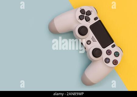 LONDON - Dezember 10, 2019: Video Game Gaming Controller auf hellen Gelb Blau Farbe Hintergrund der Ansicht von oben Stockfoto