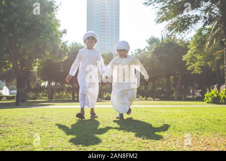 Kinder spielen zusammen in Dubai im Park. Gruppe von Kindern, die traditionelle kandura weißes Kleid aus arabischen Emirate Stockfoto