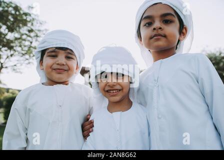 Kinder spielen zusammen in Dubai im Park. Gruppe von Kindern, die traditionelle kandura weißes Kleid aus arabischen Emirate Stockfoto