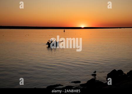 Fischer im Ruderboot bei Sonnenuntergang in der Flussmünde des Douro, Porto, Portugal. Stockfoto