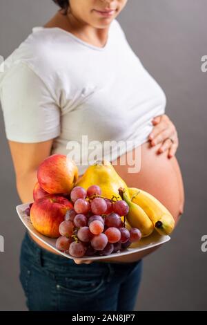 Schwangerschaft und Ernährung Diät - schwangere Frau mit Früchten. Studio shoot Stockfoto