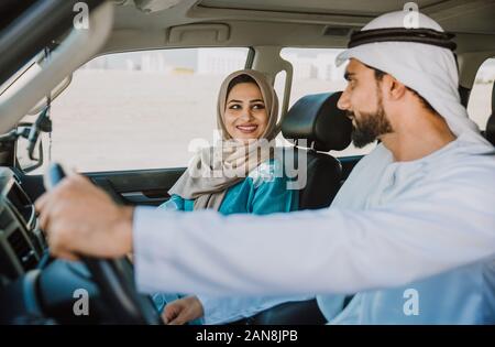 Glückliches Paar das Auto fahren in Dubai. Mann und Frau gehen zum Einkaufen. Konzept über die Beziehung in den VAE Stockfoto