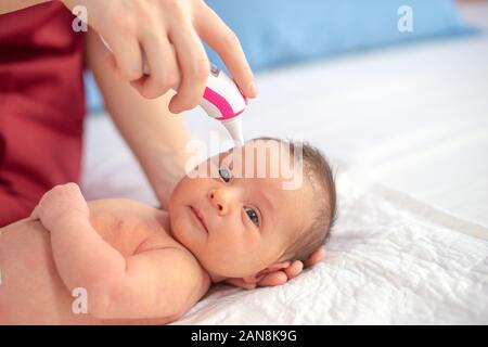 Arzt mit digitalen Thermometer prüfen neugeborenen Temperatur Stockfoto