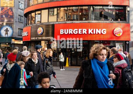 Londoner Shopper blickt auf Menschen und Touristen vor dem Burger King Fast Food Outlet Restaurant in Leicester Square, West End, London, Großbritannien Stockfoto