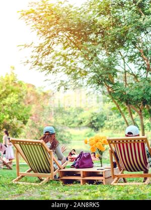 Glück Paar auf einem Sommerurlaub sitzen auf Stühlen im öffentlichen Park zu entspannen. Stockfoto