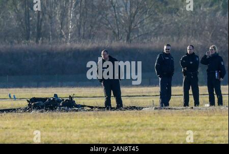 Strausberg, Deutschland. 16 Jan, 2020. Polizisten und forensische Techniker stehen neben die verkohlten Überreste eines kleinen Flugzeug auf dem Gelände des Flugplatz Strausberg. Zwei Menschen starben beim Absturz eines Kleinflugzeugs auf dem Flugplatz in Strausberg, Brandenburg. Als die Feuerwehr am Donnerstag weiter mitteilte, wurden keine weiteren Verletzten. Warum das Flugzeug stürzte zunächst unklar blieb. Foto: Patrick Pleul/dpa-Zentralbild/dpa/Alamy leben Nachrichten Stockfoto