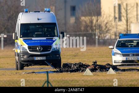 Strausberg, Deutschland. 16 Jan, 2020. Zwischen zwei Fahrzeuge der Polizei die verkohlten Überreste eines kleinen Flugzeug auf dem Gelände des Flugplatz Strausberg gesehen werden kann. Zwei Menschen starben beim Absturz eines Kleinflugzeugs auf dem Flugplatz in Strausberg, Brandenburg. Als die Feuerwehr am Donnerstag weiter mitteilte, wurden keine weiteren Verletzten. Warum das Flugzeug stürzte zunächst unklar blieb. Foto: Patrick Pleul/dpa-Zentralbild/ZB/dpa/Alamy leben Nachrichten Stockfoto